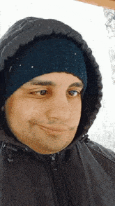 a man wearing a hooded jacket and a beanie