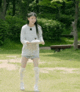 a girl in a striped shirt and shorts is holding a tray