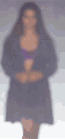 a blurred image of a woman in a purple dress
