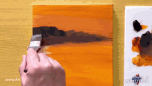 a person is painting on a canvas with a made in animatica logo