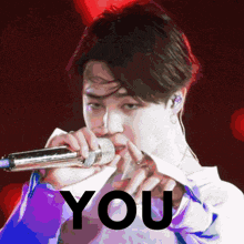 a man is singing into a microphone with the word you written below him