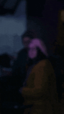 a blurry picture of people in a dark room with purple lighting
