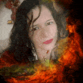 a woman wearing a necklace with the letter a on it is surrounded by flames