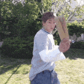 a man in a gray shirt is holding a cardboard box