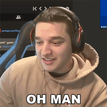 a man wearing headphones says " oh man " in front of a computer screen