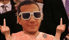 a man wearing sunglasses giving the middle finger