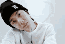 a young man wearing a black beanie and headphones looks at the camera .