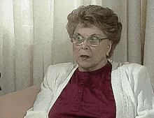 a woman wearing glasses is sitting on a couch