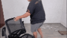 a man in a blue shirt is pushing a wheelchair .