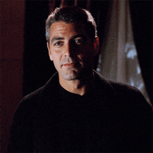 a close up of a man 's face with a black shirt