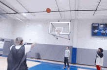 people playing basketball in a gym with a scoreboard that says home on it