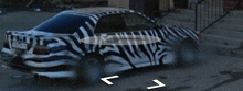 a black and white zebra print car with a license plate that says a4124wm