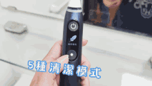 a person is holding a toothbrush in front of a mirror with chinese writing on it