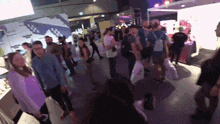 a crowd of people are gathered in a room with a purple wall