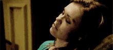 a woman is laying on a couch with her eyes closed and her head on her chest .