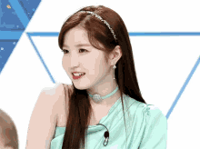 a woman wearing a headband and a choker looks to the side