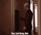 a man standing in a doorway with the words tea earl grey hot written on it