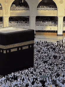 a large crowd of people are gathered in front of a building with arabic writing on the side