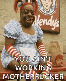 a wendy 's sign is behind a woman in a wendy 's outfit
