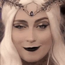 a close up of a woman wearing a crown and a wig .