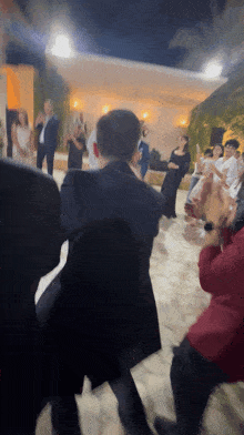 a man in a suit is dancing with a group of people