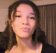 a woman with curly hair is making a funny face