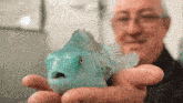 a man is holding a blue fish in his hands