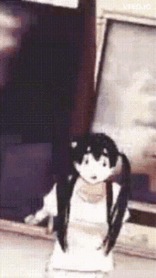 a doll with pigtails is sitting on a table in front of a tv .