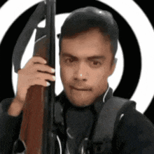 a man is holding a rifle in front of a circle .