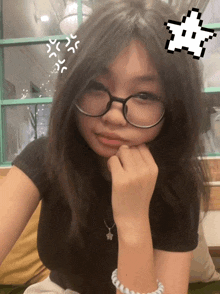 a girl wearing glasses and a black shirt has an angry face drawn on her head