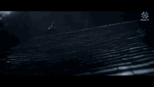 a dinosaur is standing on top of a building at night .
