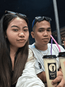a man and a woman are drinking from a cup that says ' wurm ' on it