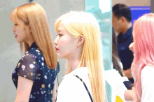 a woman with blonde hair stands next to two other women
