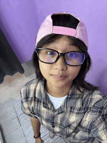 a girl wearing glasses and a pink hat