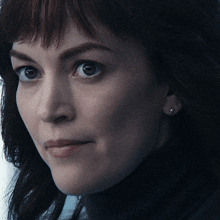 a close up of a woman 's face with a turtleneck