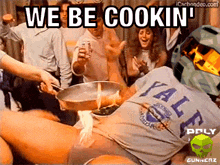 a man wearing a yale shirt is cooking a meal