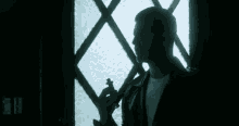 a man in a leather jacket holds a knife in front of a window