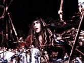 a man playing drums in a dark room with a microphone