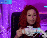 a woman with red hair sitting in front of a microphone