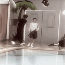 two people are standing in front of a door with a palm tree painted on it