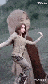 a woman in a hijab is dancing in front of a blurred image of herself .