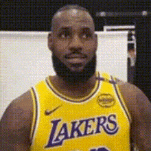a man with a beard is wearing a lakers jersey .