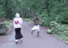 a woman wearing a white sweatshirt with a heart on the back is running down a path