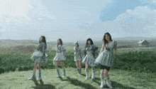 a group of girls are standing in a grassy field and one of them has the letter s on her top