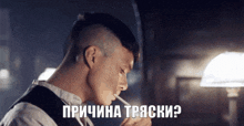 a man is smoking a cigarette in a dark room with the words " причина тряски " written on the bottom