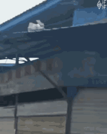 a blue tarp is covering a building that has a hole in it .