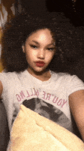 a girl with curly hair is wearing a t-shirt that says ' uoy '