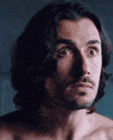 a man with long hair and a beard looks surprised