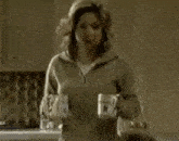 a woman is standing next to a man holding a cup