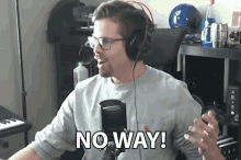 a man wearing headphones and glasses says " no way " in front of a microphone